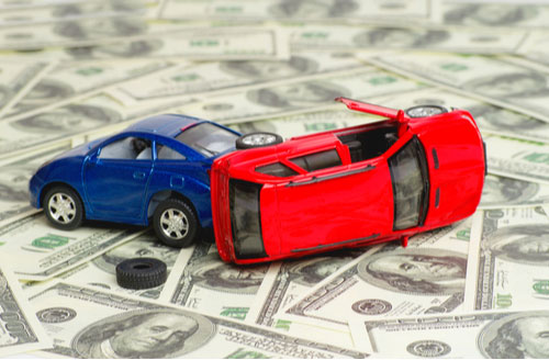 Toy cars on pile of money, car accident compensation concept