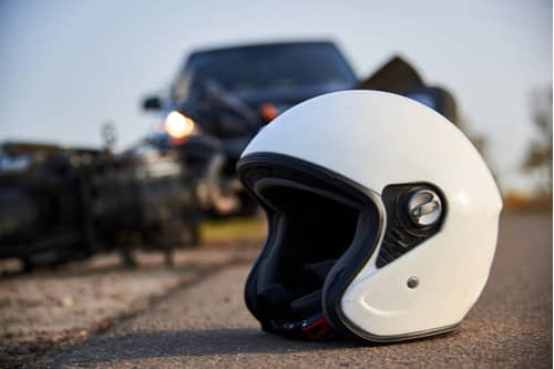 car, helmet and motorcycle on road, South Fulton motorcycle accident lawyer concept