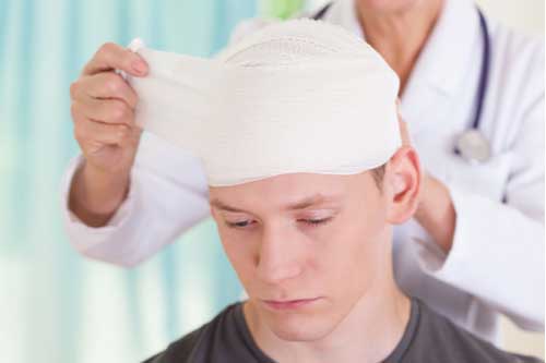 Doctor bandaging head of young man, South Fulton personal injury lawyer concept
