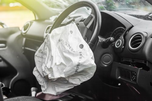 Deployed airbag in car concept of Fairburn car accident lawyer