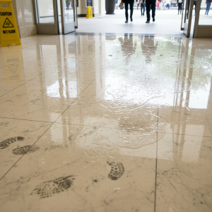 Close-up of wet, slippery floor creating a hazardous slip and fall environment in a commercial building
